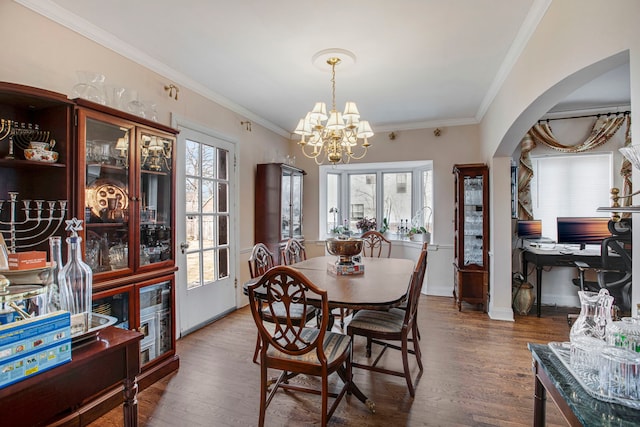 dining space with a wealth of natural light, crown molding, and wood finished floors