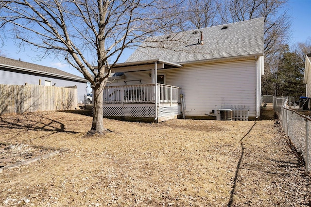 rear view of property featuring cooling unit, roof with shingles, fence, and a wooden deck