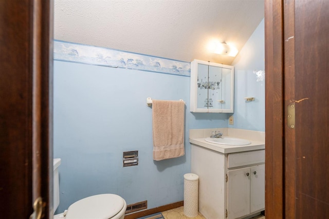 half bath with toilet, visible vents, vanity, vaulted ceiling, and baseboards