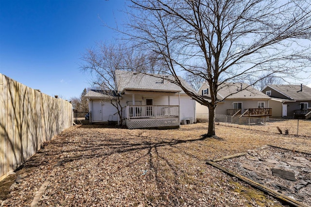 rear view of house with a fenced backyard and a wooden deck