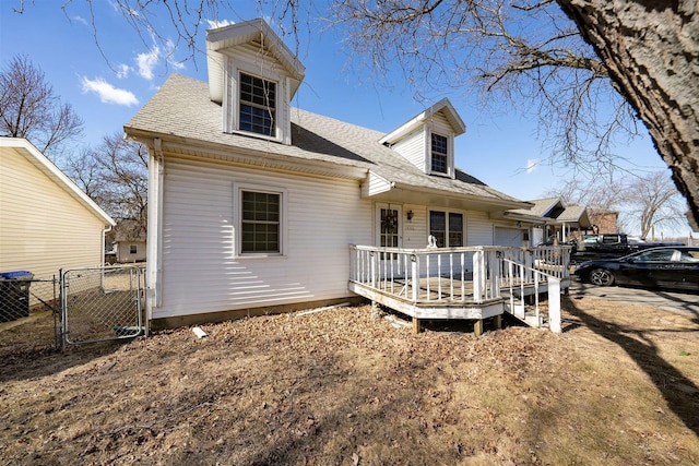 rear view of house featuring central air condition unit, a shingled roof, fence, a wooden deck, and a gate