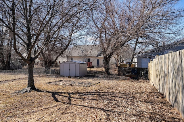 view of yard with a fenced backyard, an outdoor structure, and a storage unit