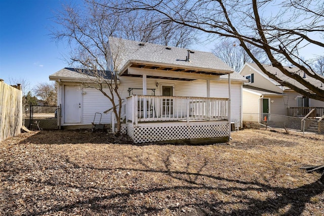 back of property featuring a fenced backyard, a deck, and roof with shingles