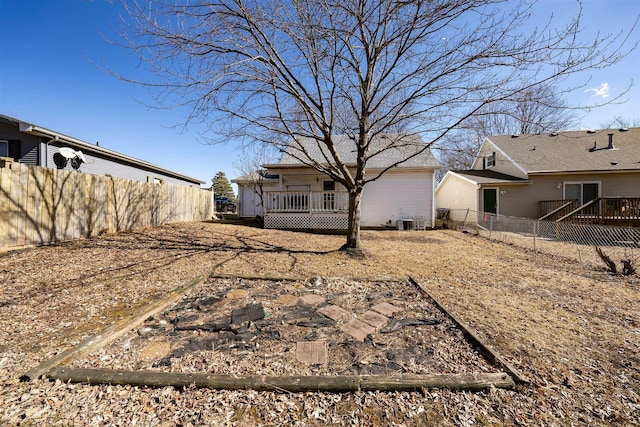 view of yard featuring central AC unit, a fenced backyard, and a wooden deck