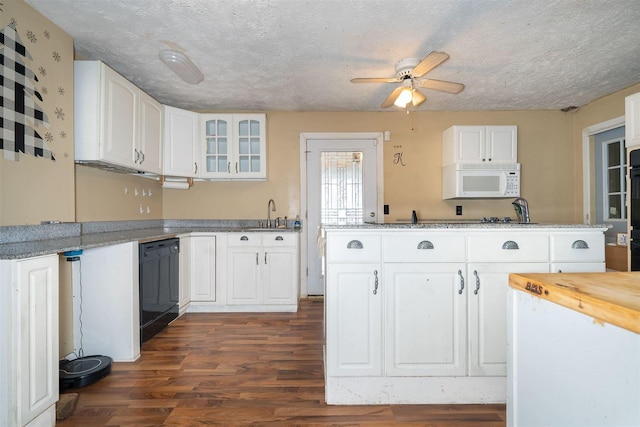 kitchen featuring dishwasher, white microwave, glass insert cabinets, dark wood-type flooring, and white cabinetry