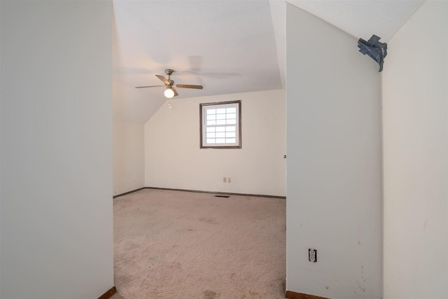 additional living space with lofted ceiling, carpet, a ceiling fan, and baseboards