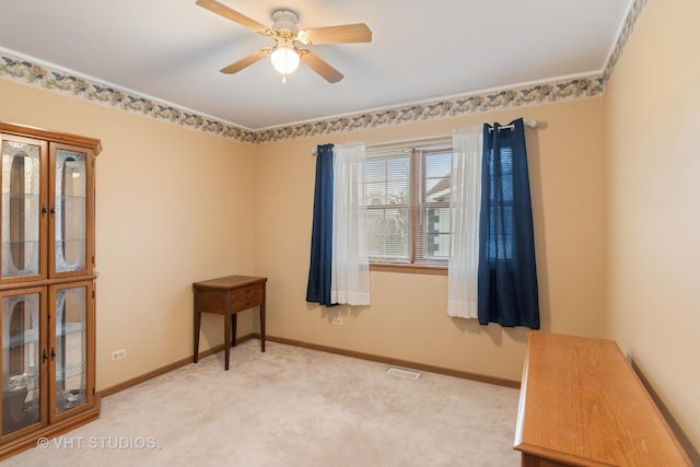 spare room featuring light colored carpet, visible vents, ceiling fan, and baseboards