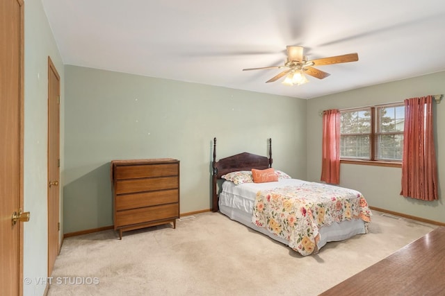 bedroom featuring light carpet, ceiling fan, visible vents, and baseboards