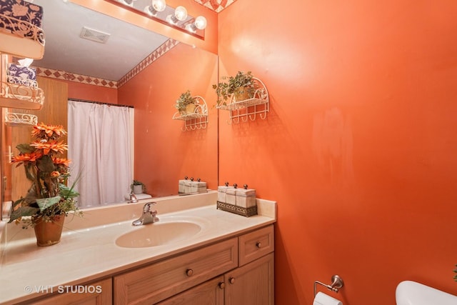 full bath with visible vents, a shower with shower curtain, vanity, and toilet