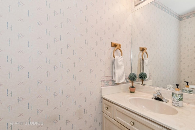 bathroom with wallpapered walls and vanity