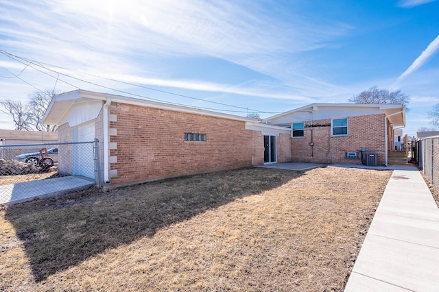 view of side of property with brick siding, fence, and central AC unit