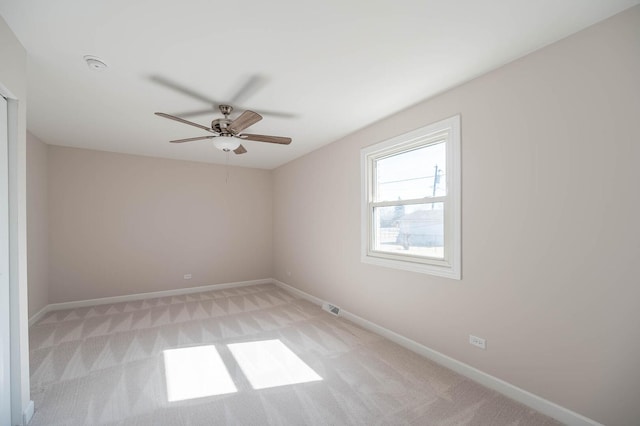 unfurnished room with light carpet, visible vents, and baseboards