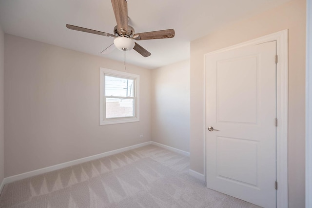 unfurnished room featuring light carpet, ceiling fan, and baseboards