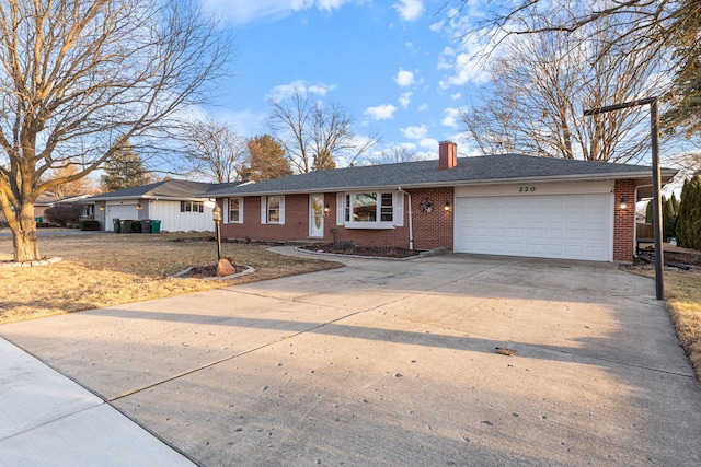 ranch-style house with a garage, driveway, a chimney, roof with shingles, and brick siding