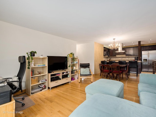 living room featuring a chandelier and light wood-type flooring