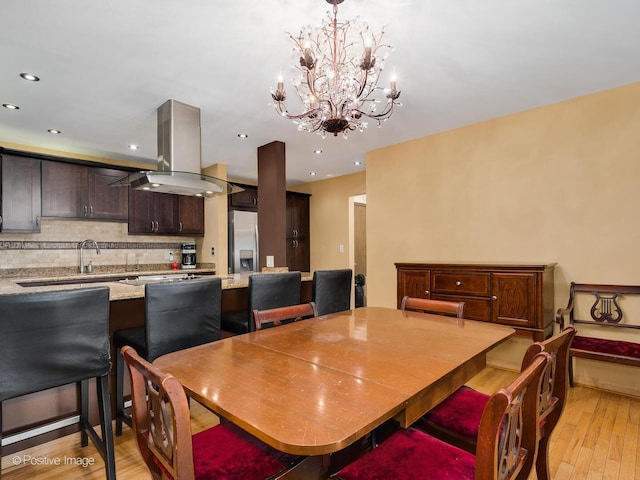 dining room with light wood-type flooring, an inviting chandelier, and recessed lighting