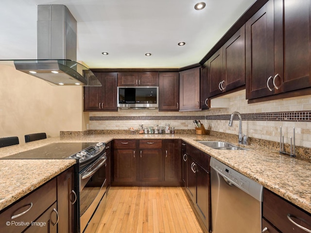 kitchen featuring dark brown cabinetry, stainless steel appliances, a sink, light wood finished floors, and island exhaust hood