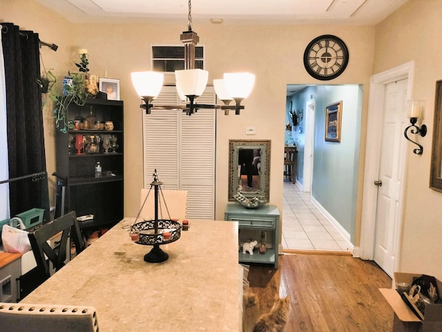 dining room featuring a chandelier, wood finished floors, and baseboards