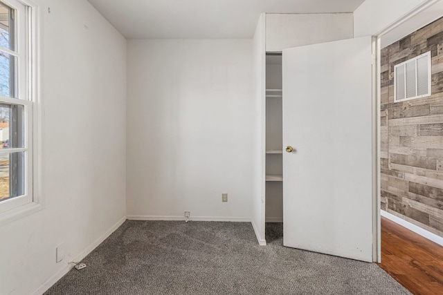 unfurnished bedroom with baseboards, multiple windows, visible vents, and carpet flooring