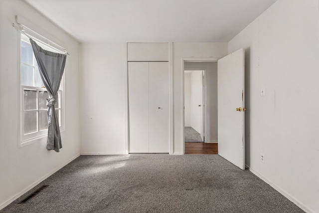 unfurnished bedroom with a closet, visible vents, and carpet