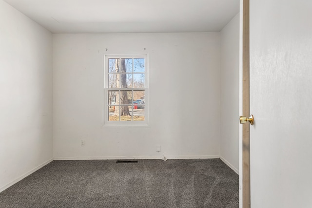 spare room with carpet, visible vents, and baseboards