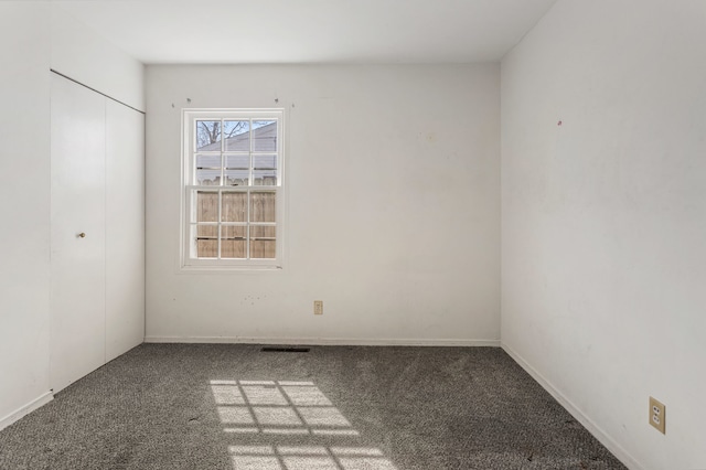 carpeted empty room with baseboards