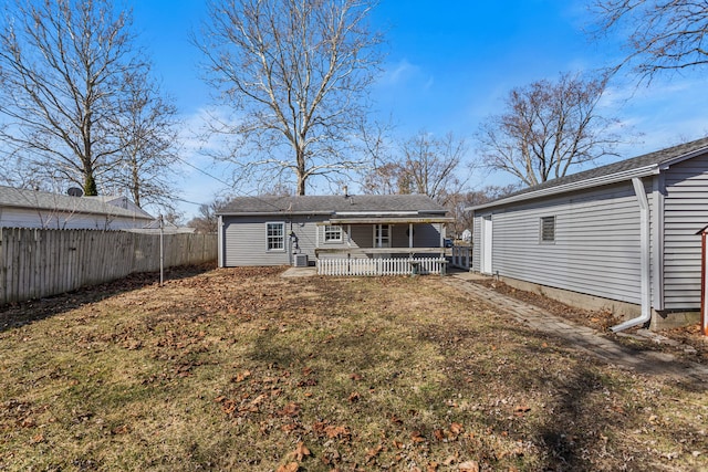 back of property featuring fence and a lawn