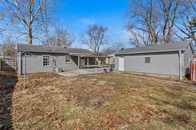 rear view of house featuring a yard, a patio, an outdoor structure, and fence