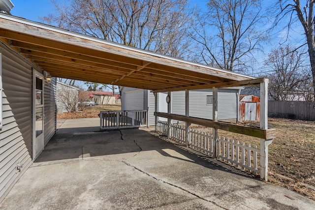 view of patio with a carport, fence, and an outdoor structure