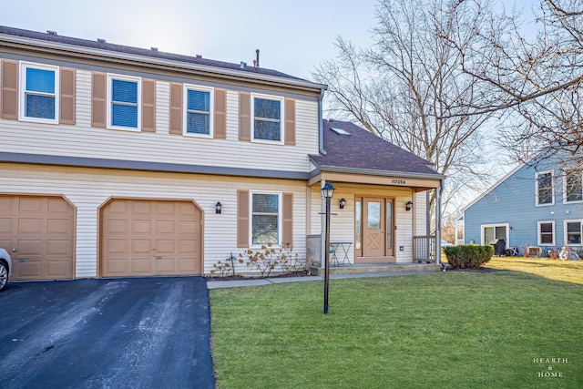 view of front of property featuring a garage, a front lawn, and aphalt driveway