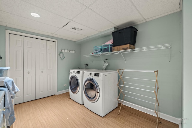 laundry area with washer and dryer, visible vents, light wood-type flooring, laundry area, and baseboards