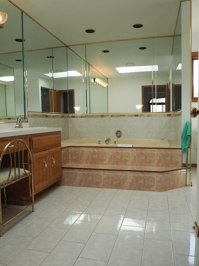 bathroom with tile patterned flooring, a bath, and vanity