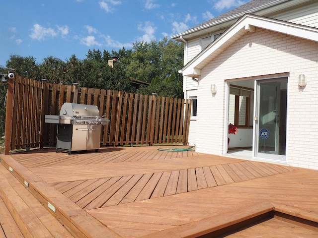 wooden deck featuring fence and area for grilling