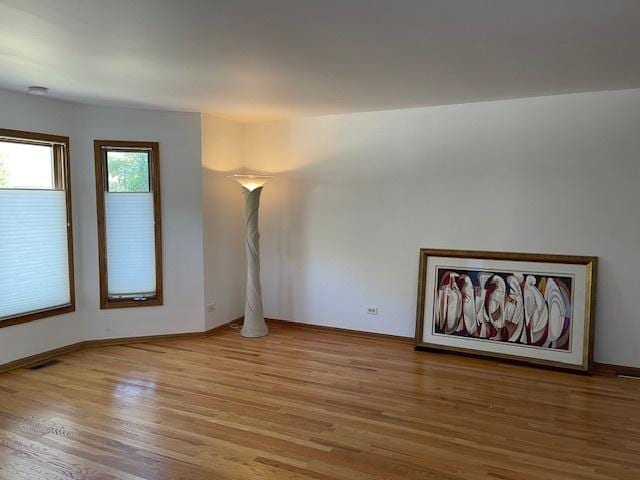 spare room featuring visible vents and wood finished floors