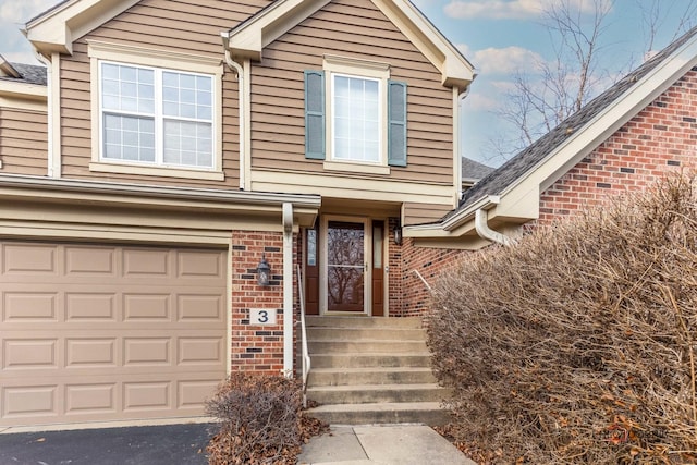 view of front of home with a garage, driveway, and brick siding