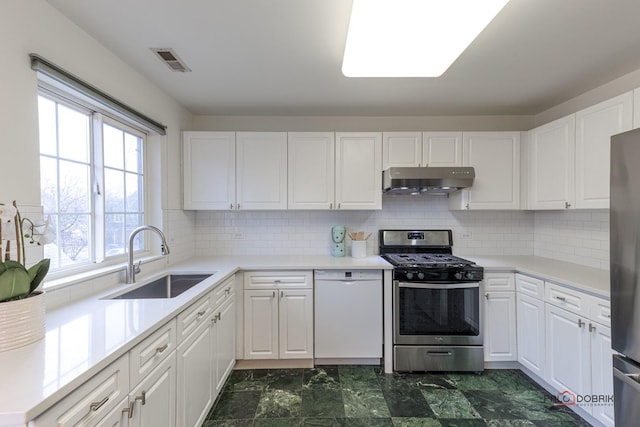 kitchen with stainless steel appliances, visible vents, white cabinetry, a sink, and under cabinet range hood