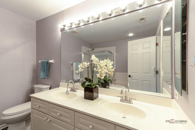 full bath with visible vents, a sink, toilet, and a shower stall