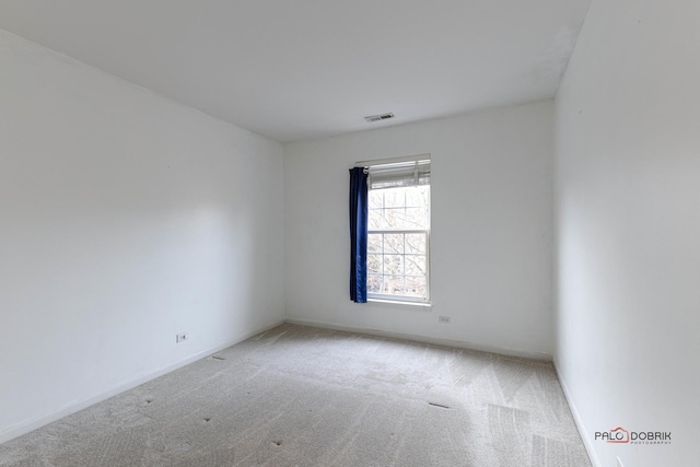 spare room featuring carpet, visible vents, and baseboards