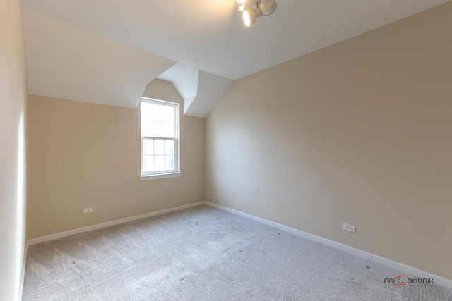 additional living space with vaulted ceiling, carpet flooring, and baseboards