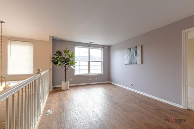 spare room featuring light wood-style floors and baseboards