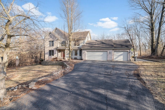 view of front facade featuring aphalt driveway, brick siding, and an attached garage