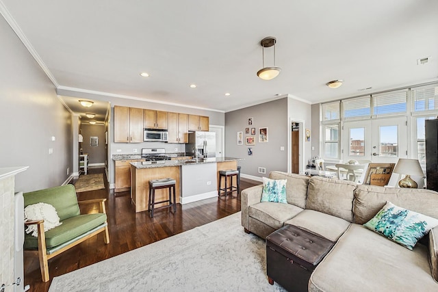 living area featuring baseboards, visible vents, dark wood finished floors, ornamental molding, and recessed lighting