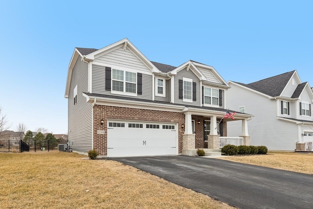 view of front of property featuring aphalt driveway, brick siding, central AC, fence, and a front lawn