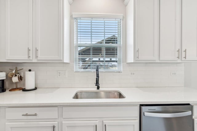 kitchen with decorative backsplash, white cabinetry, dishwasher, and a sink