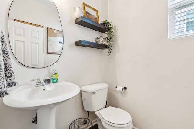 half bathroom with toilet and baseboards