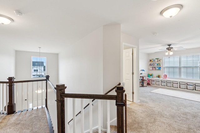 hallway featuring carpet flooring and an upstairs landing