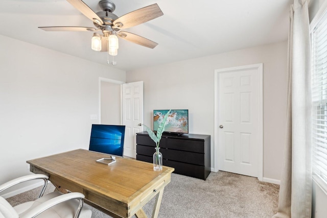 office featuring light carpet, ceiling fan, and baseboards