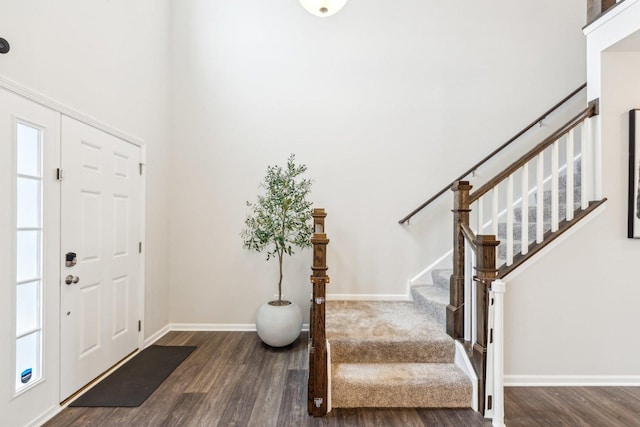 entrance foyer with stairs, wood finished floors, and baseboards