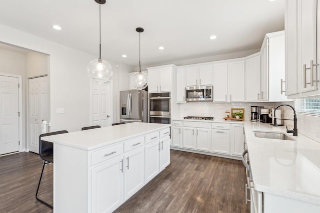 kitchen with a center island, stainless steel appliances, tasteful backsplash, a sink, and a kitchen breakfast bar