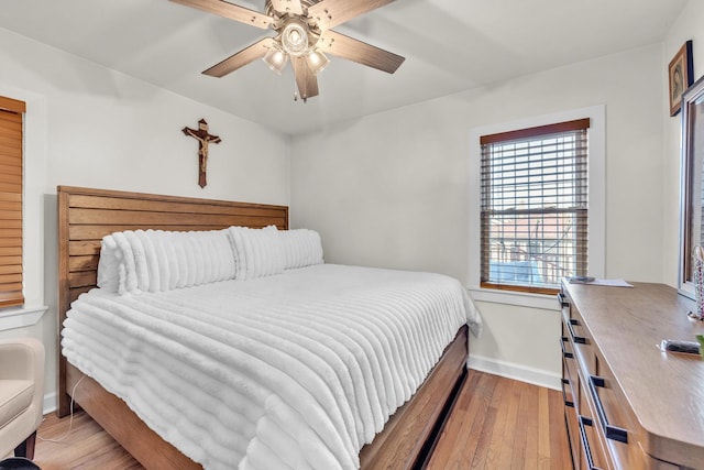 bedroom featuring hardwood / wood-style flooring, baseboards, and a ceiling fan